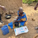 Elderly woman receiving food assistance through Mission of Hope Uganda.