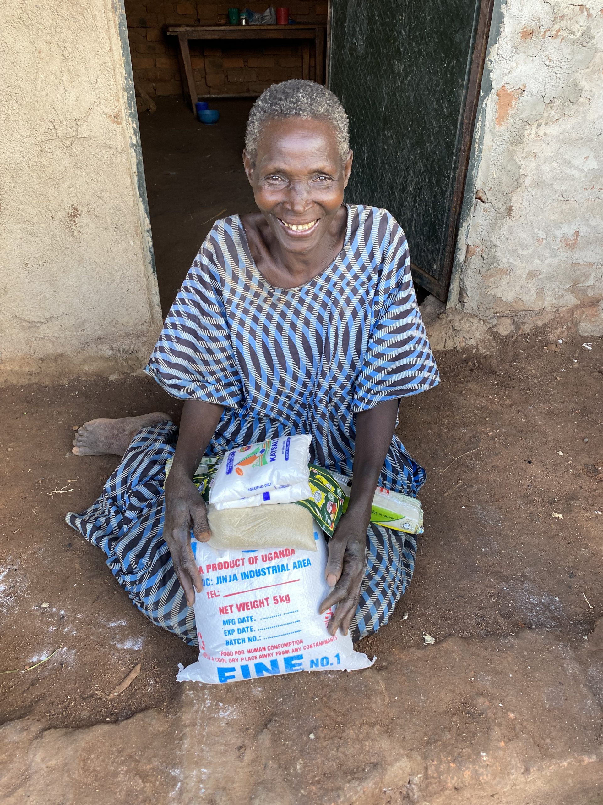Elderly woman receiving food assistance through Mission of Hope Uganda.